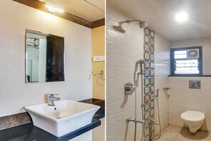 Un baño con lavamanos blanco, un espejo y una ducha con pared de azulejos.