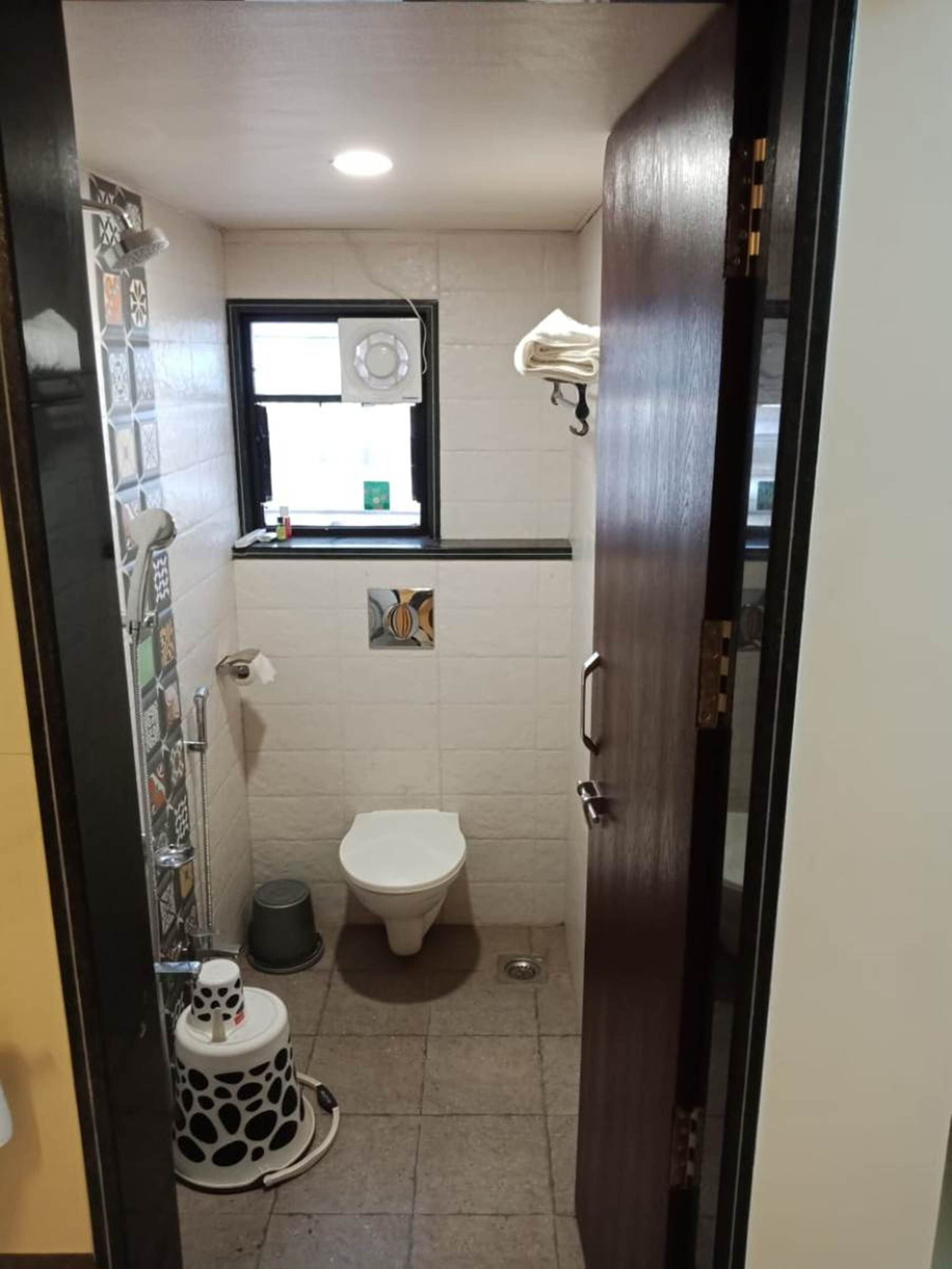 Un baño pequeño y funcional con inodoro, lavamanos y ventana.