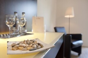 A bar area with a tray of snacks, a lamp, and a bottle of water. - Hotel Meiners (Hatten)