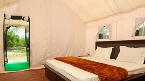 A tented room with a bed, a window, and a view of greenery outside. - Ladakh Tarrain Camp (Leh)