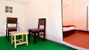 A tent with two wooden chairs, a small table, and a bed. - Ladakh Tarrain Camp (Leh)