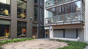 A modern building with a courtyard featuring a circular garden and a seating area.