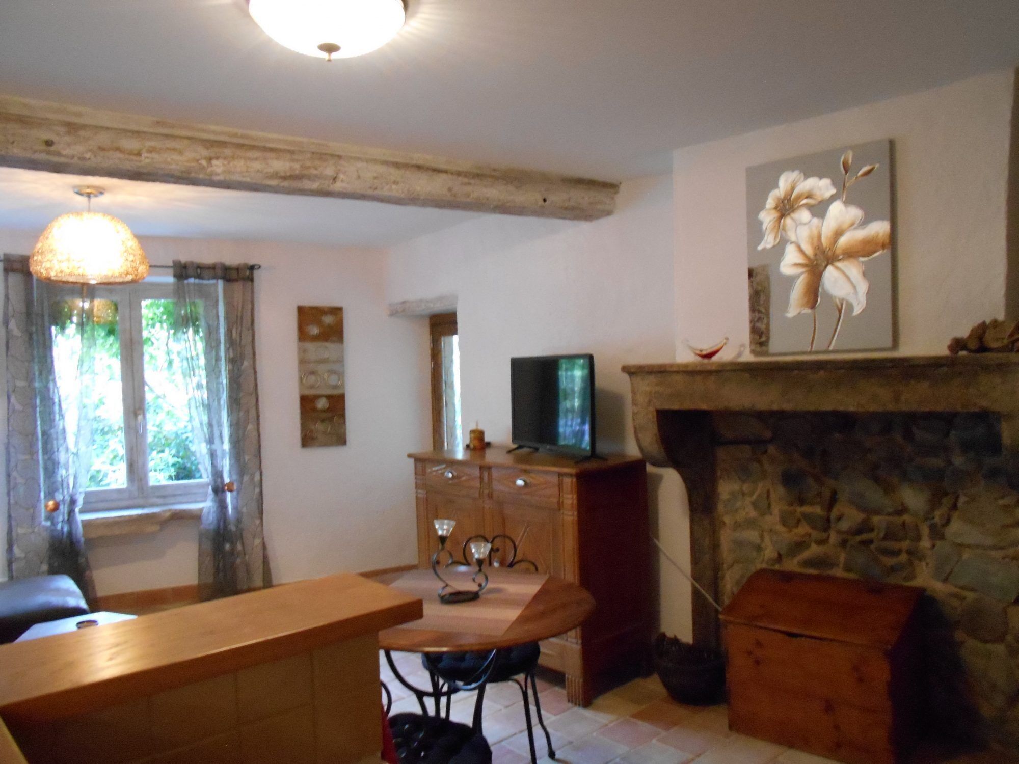 Una sala de estar acogedora con chimenea de piedra, muebles de madera y un televisor sobre un soporte de madera.