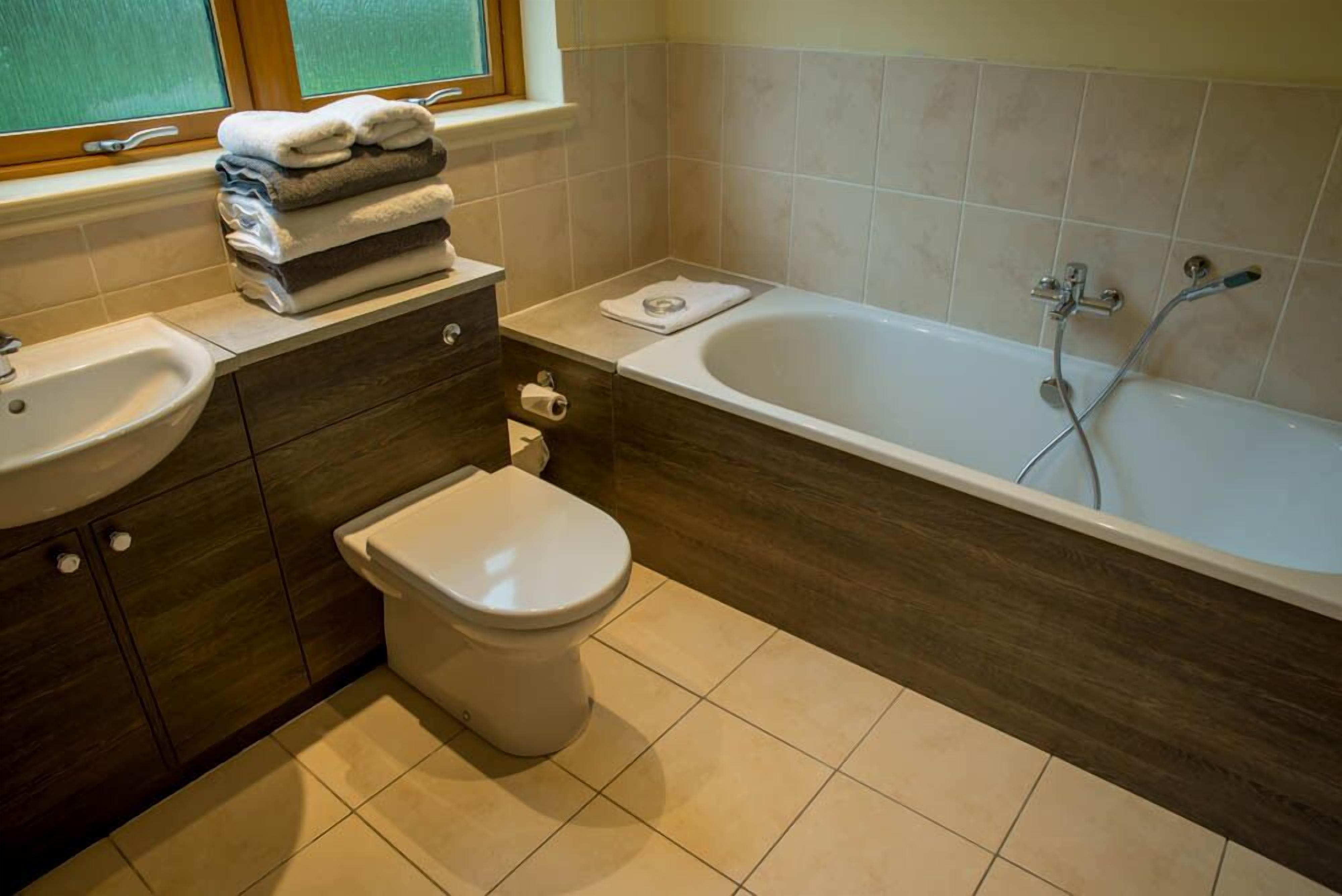 Une salle de bain avec des toilettes, un lavabo et une baignoire.