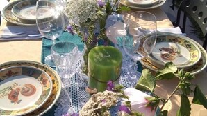 A table set for a meal with plates, glasses, and a centerpiece of flowers. - Gli Archi (Fauglia)