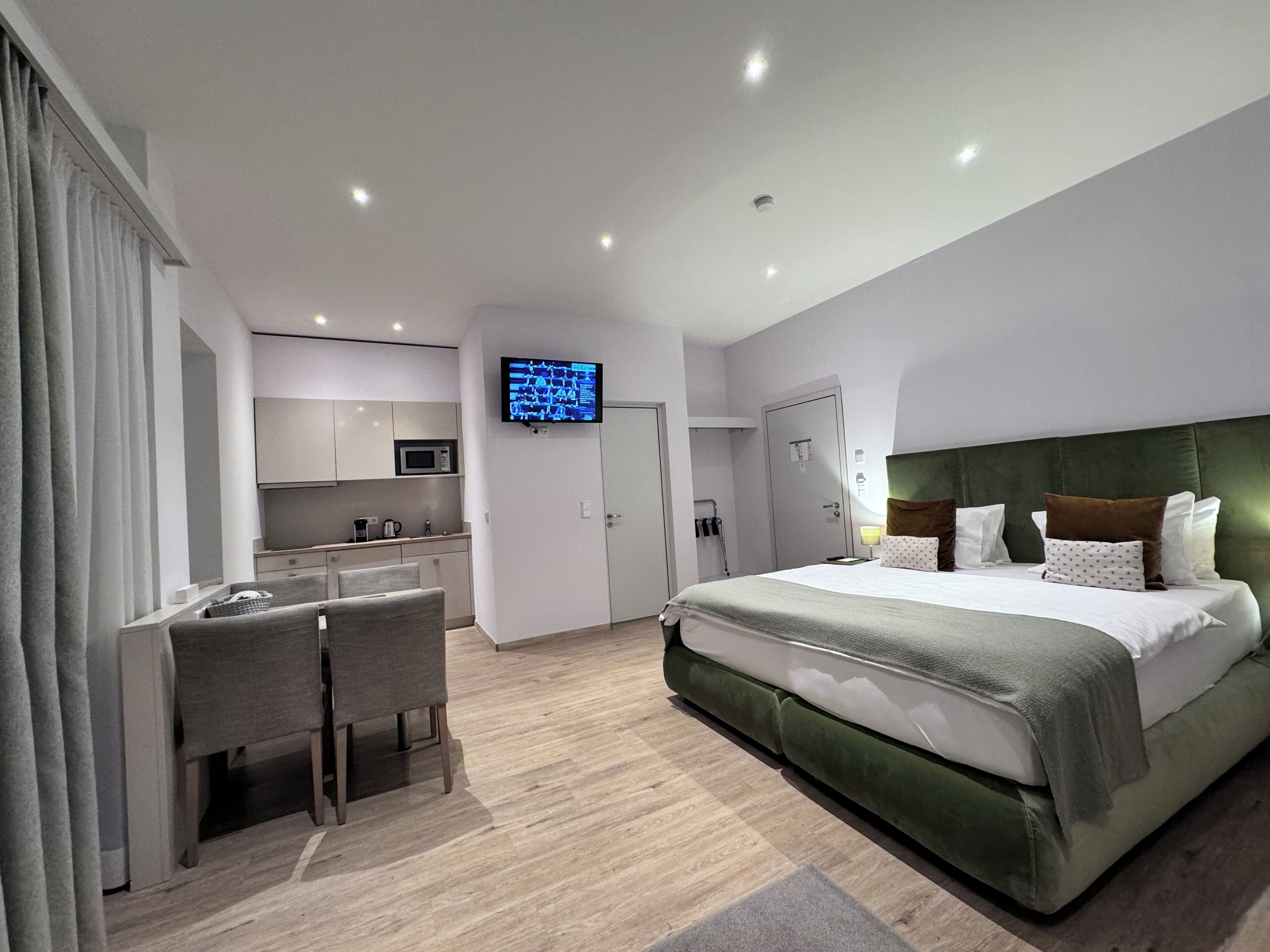 Ein modernes Hotelzimmer mit einem großen Bett, einem Schreibtisch und einem Fernseher.