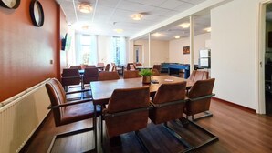 A conference room with a long table, chairs, and a pool table. - Hotel Eckhardt (Uithuizen)