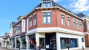 A corner building with a prominent hotel sign, large windows, and a bicycle parked outside. - Hotel Eckhardt (Uithuizen)