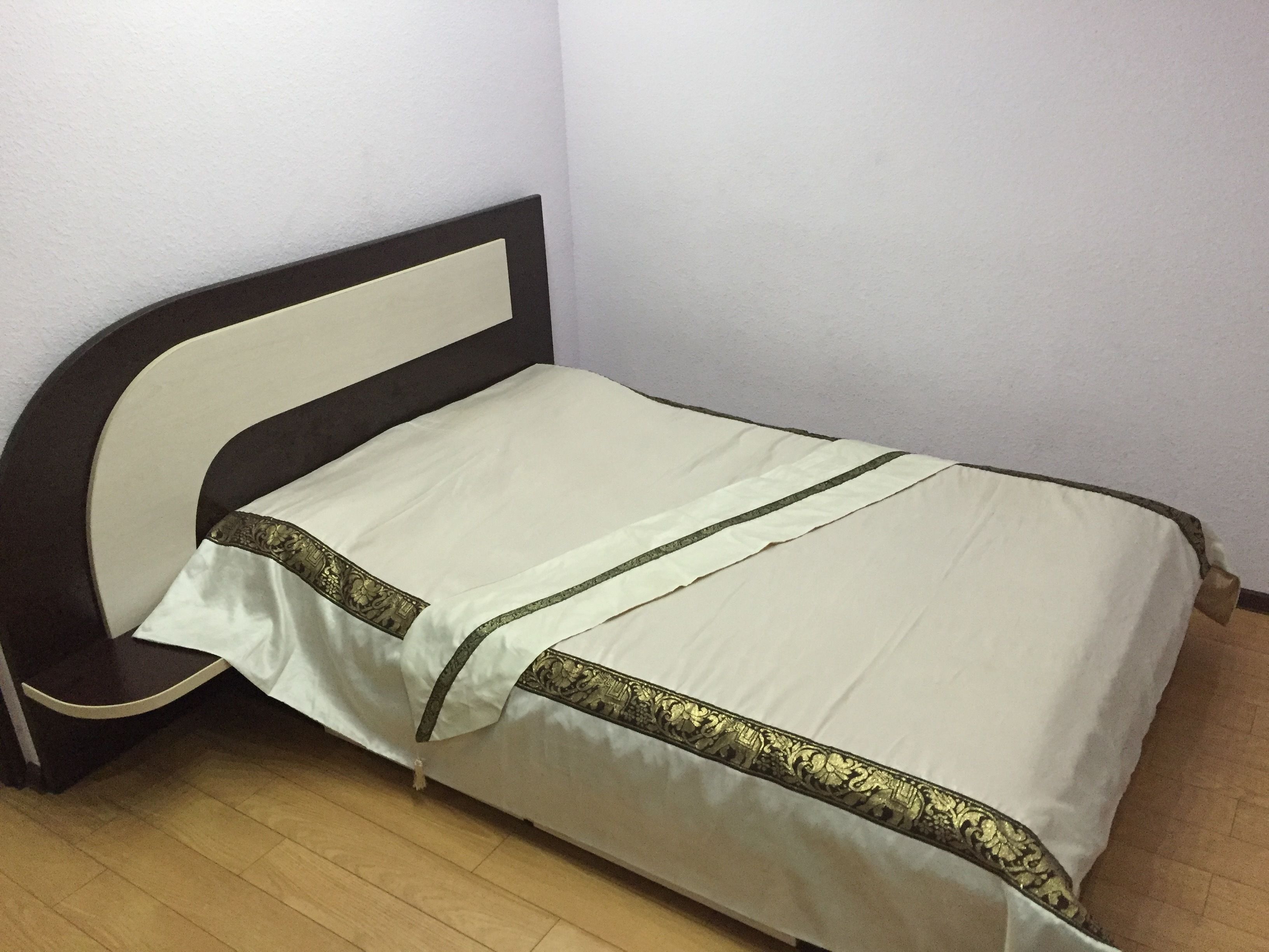 Ein Bett mit Kopfteil, einer weißen Matratze und einer Zierleiste.
