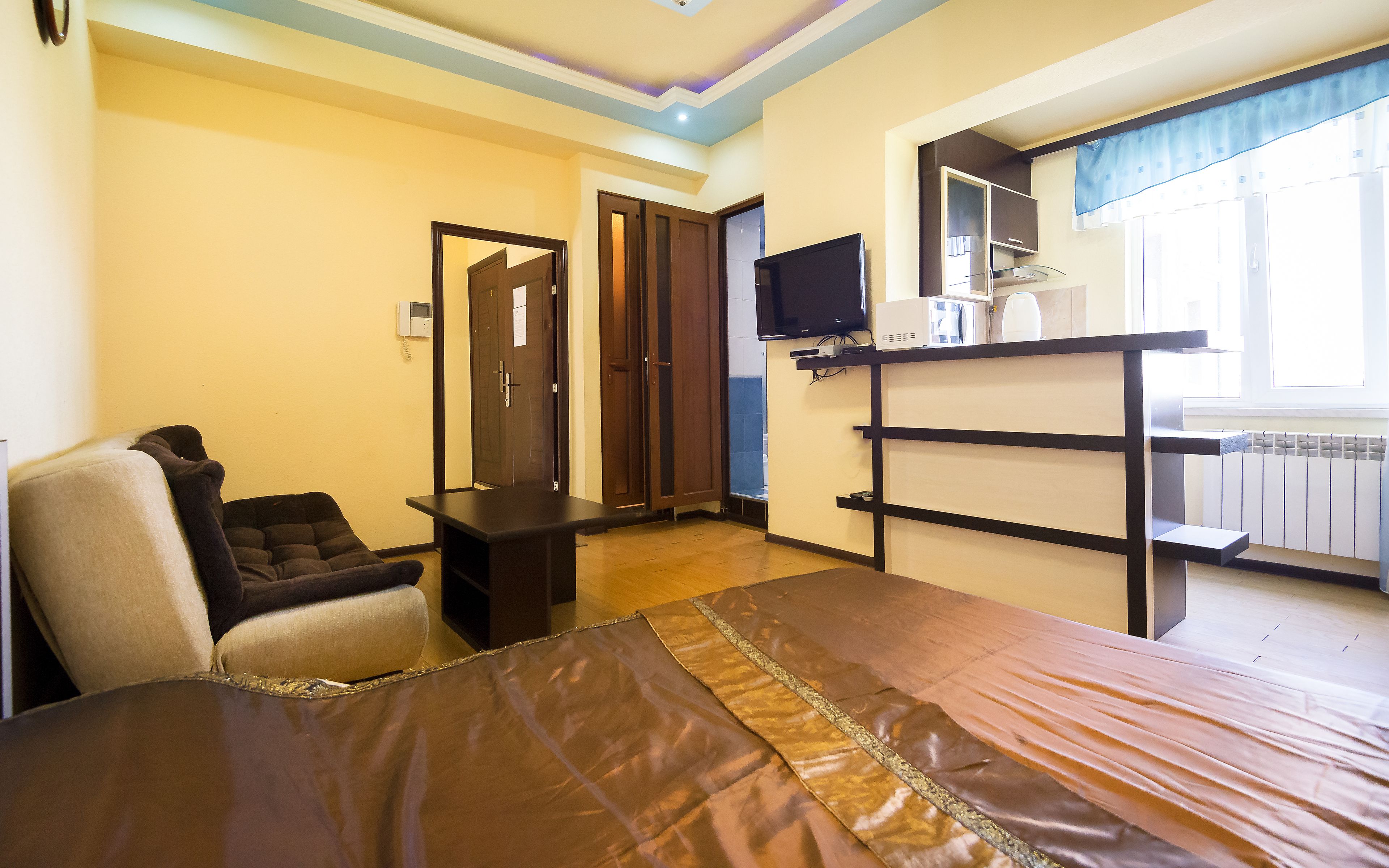 Quarto de hotel com uma cama, televisão, escrivaninha e uma cadeira.