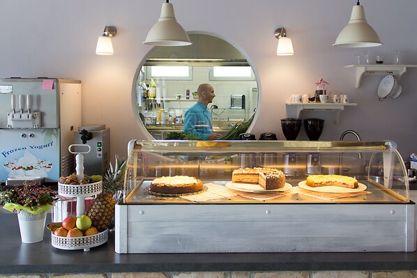 A bakery display case with cakes and a fruit stand. - Villa Meehr (Wusterhausen/Dosse)