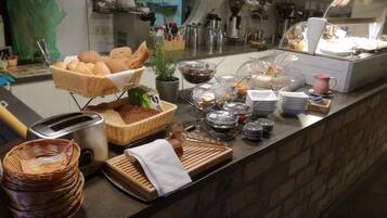 Disposição de buffet com diversos alimentos e utensílios.