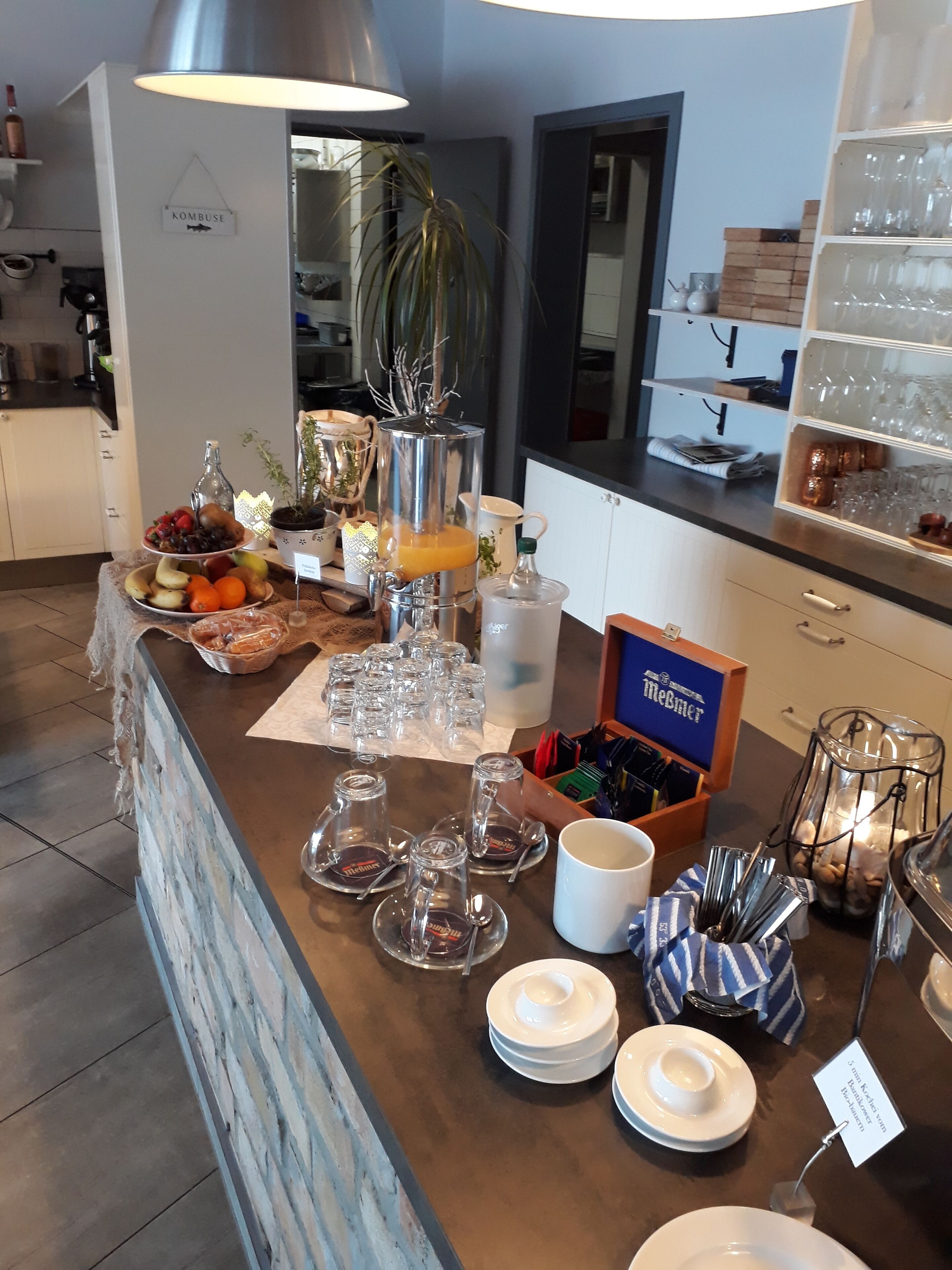 A buffet setup with a variety of food items, glassware, and a coffee station.
