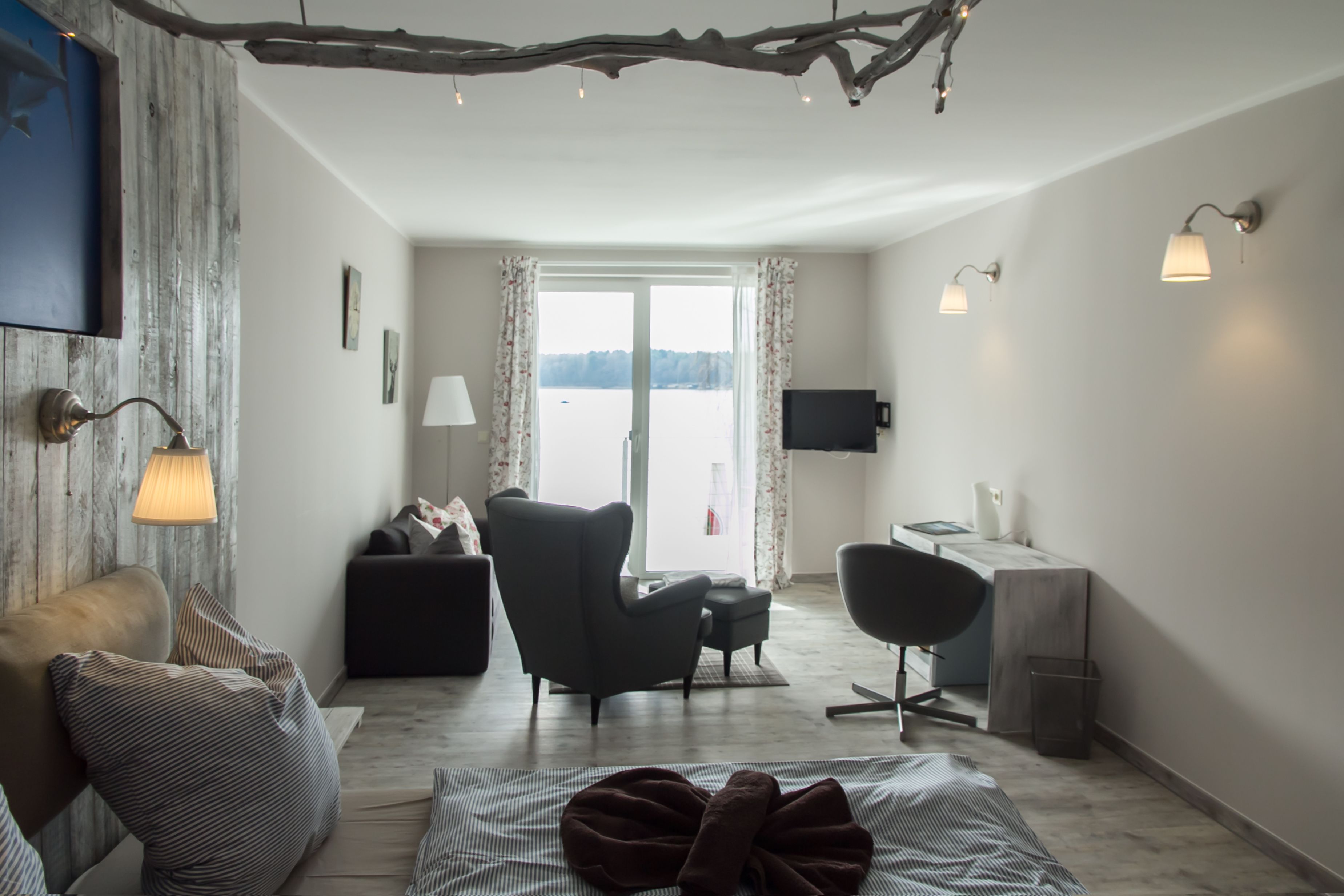 Uma sala de estar moderna com sofá, poltrona e um espaço de jantar com mesa e cadeiras.
