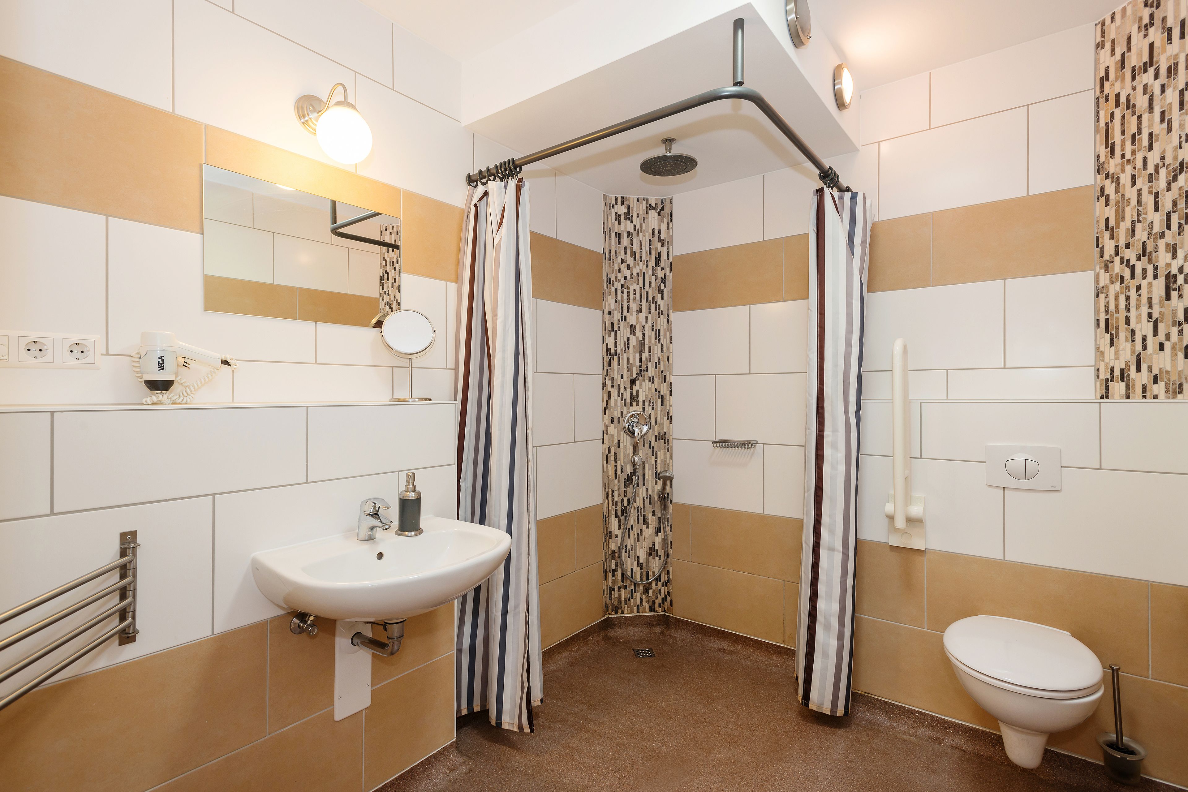A modern bathroom with a shower, sink, and toilet.