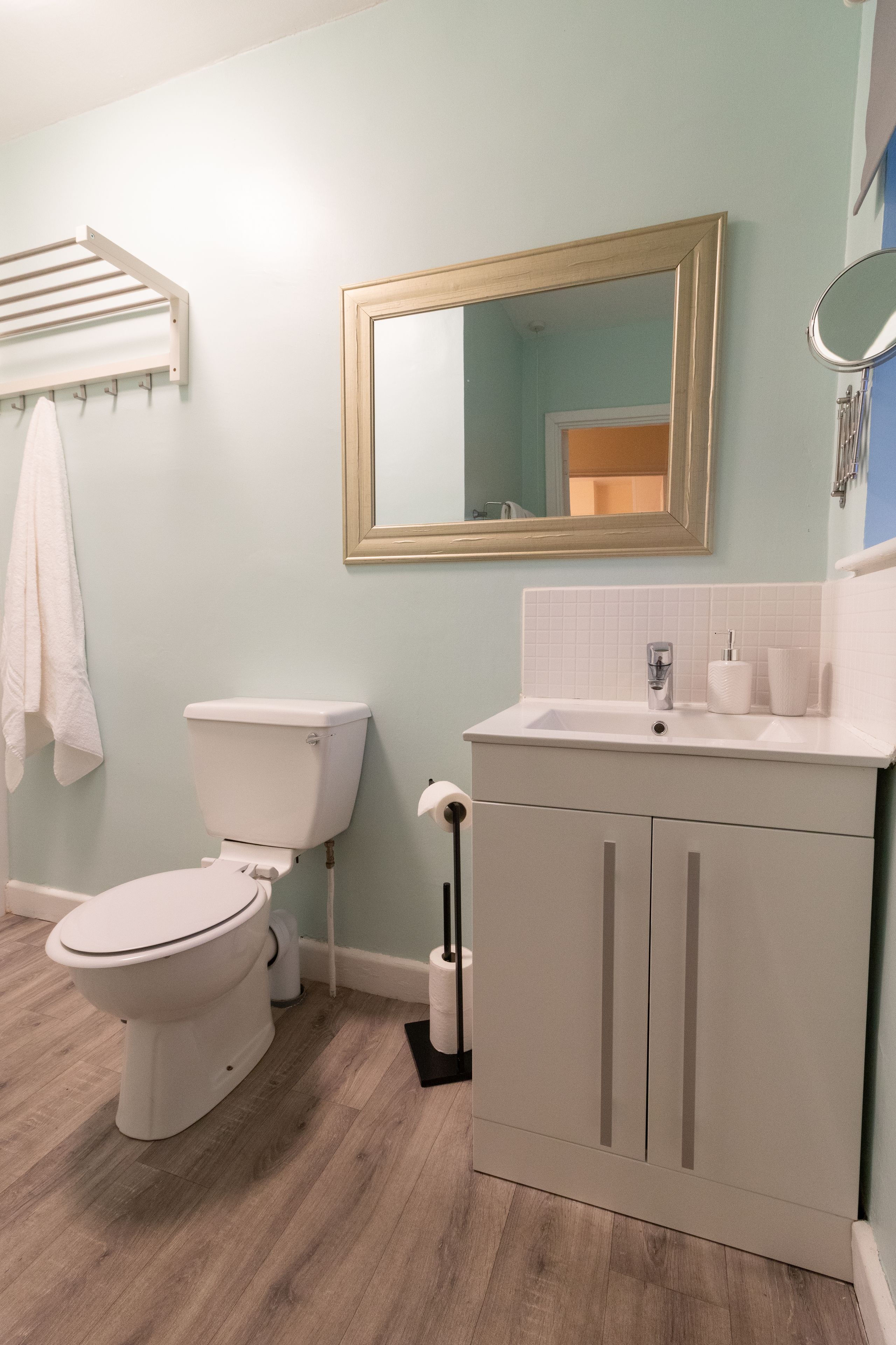 Une salle de bain avec des toilettes, un lavabo et un miroir.