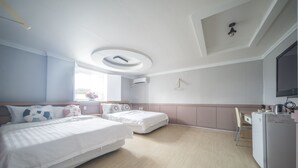 A modern hotel room with two beds, a desk, a refrigerator, and a TV.