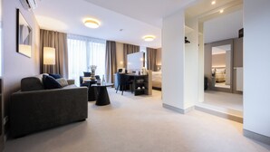 A modern hotel room with a sofa, desk, and a bed. - Digital Hotel Kronjuwel by BRIGHT Waldkirch - Self Check-in (Waldkirch)