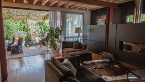 Un salon moderne avec un ensemble de canapés, une cheminée et une vue sur l’extérieur.