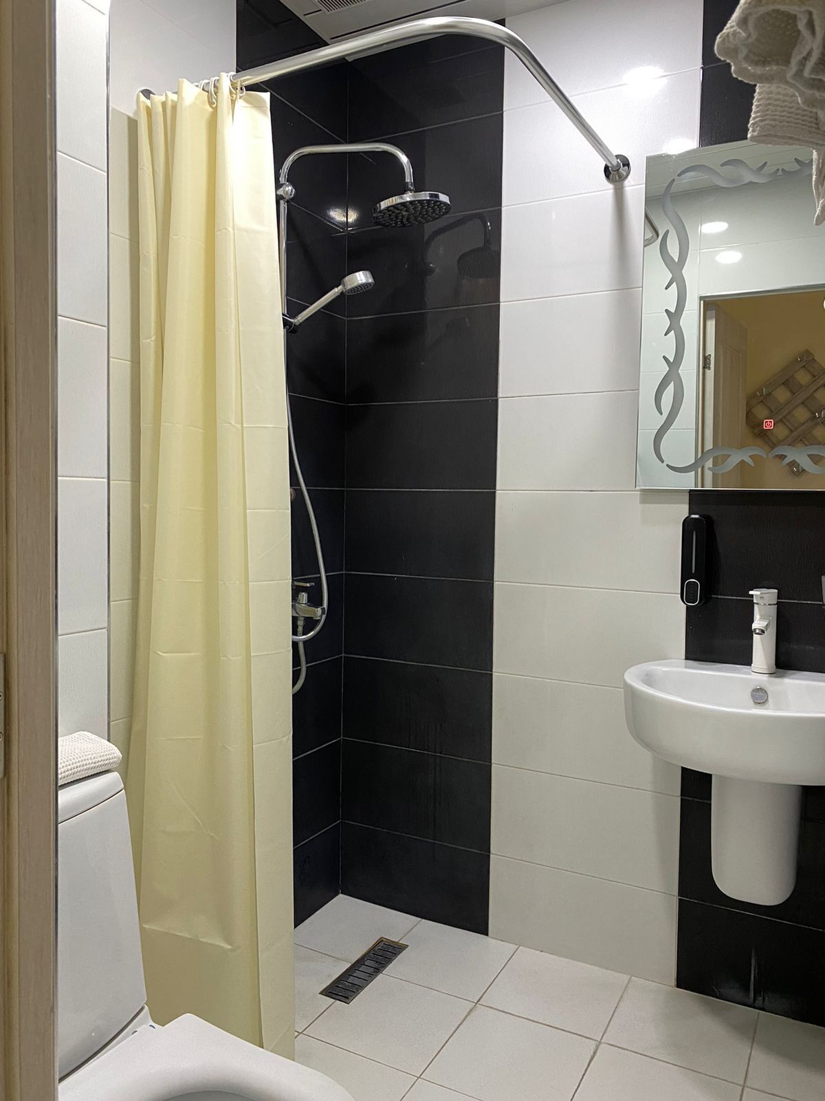 A bathroom with a shower, toilet, and sink.