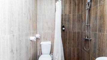 A modern bathroom with a shower, toilet, and sink.