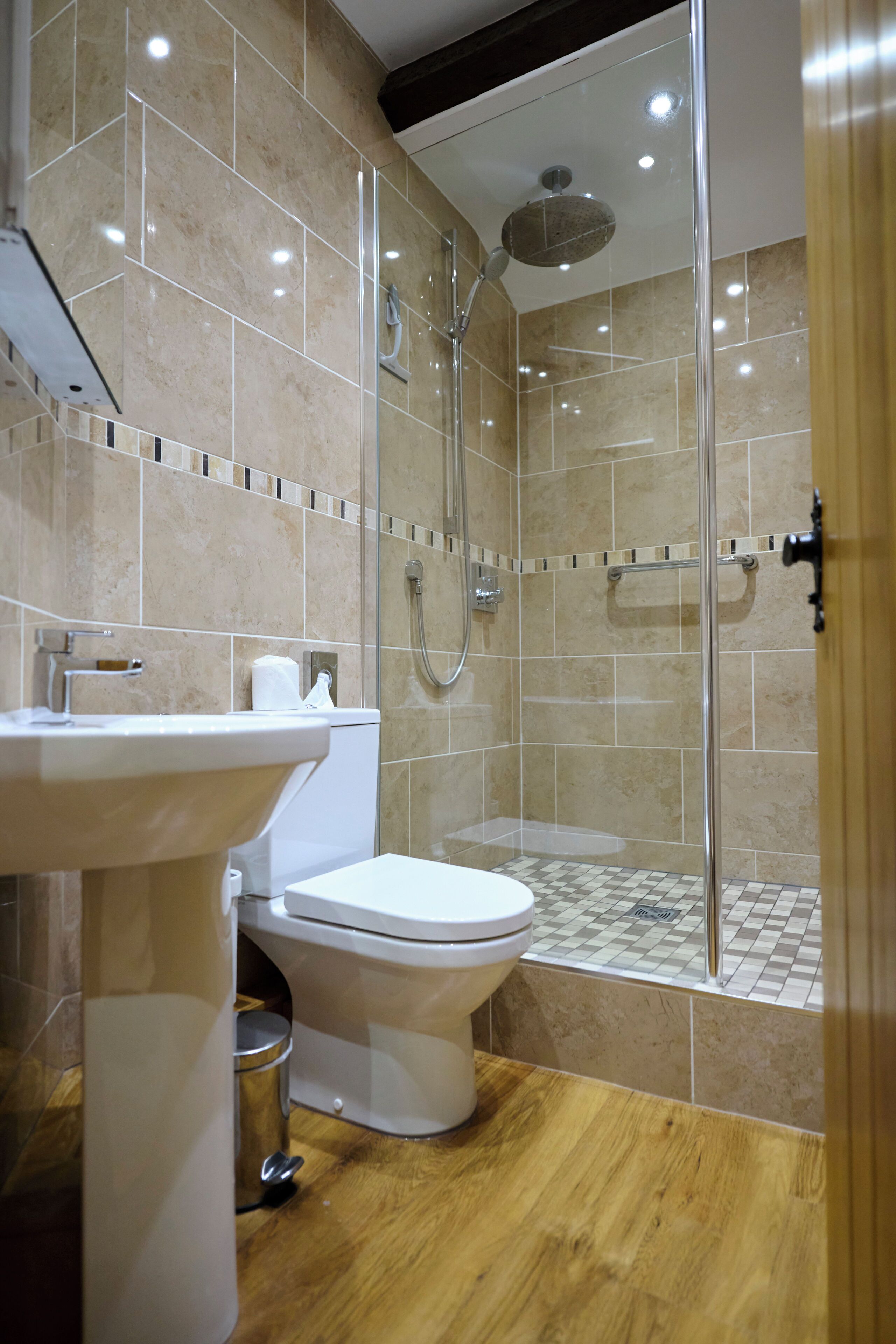 Une salle de bain moderne avec une douche à parois de verre, un lavabo blanc et des toilettes.