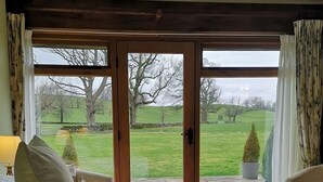 A bedroom with a large sliding glass door leading to a garden. - GreenGrove Country House B&B (Skipton)