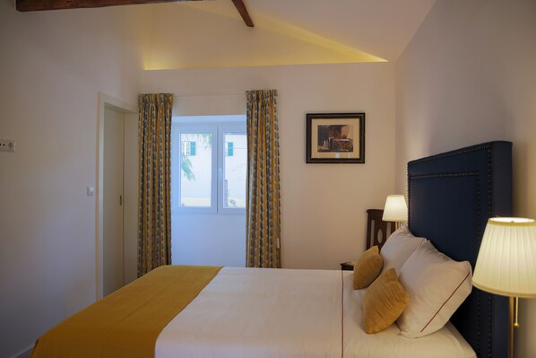 A hotel room with a bed, a nightstand, a lamp, and a framed picture on the wall. - Quinta da Pousada (Santa Marta de Penaguião)