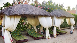 A beachside lounge area with thatched umbrellas and colorful cushions. - Pousada Polymar (Maragogi)