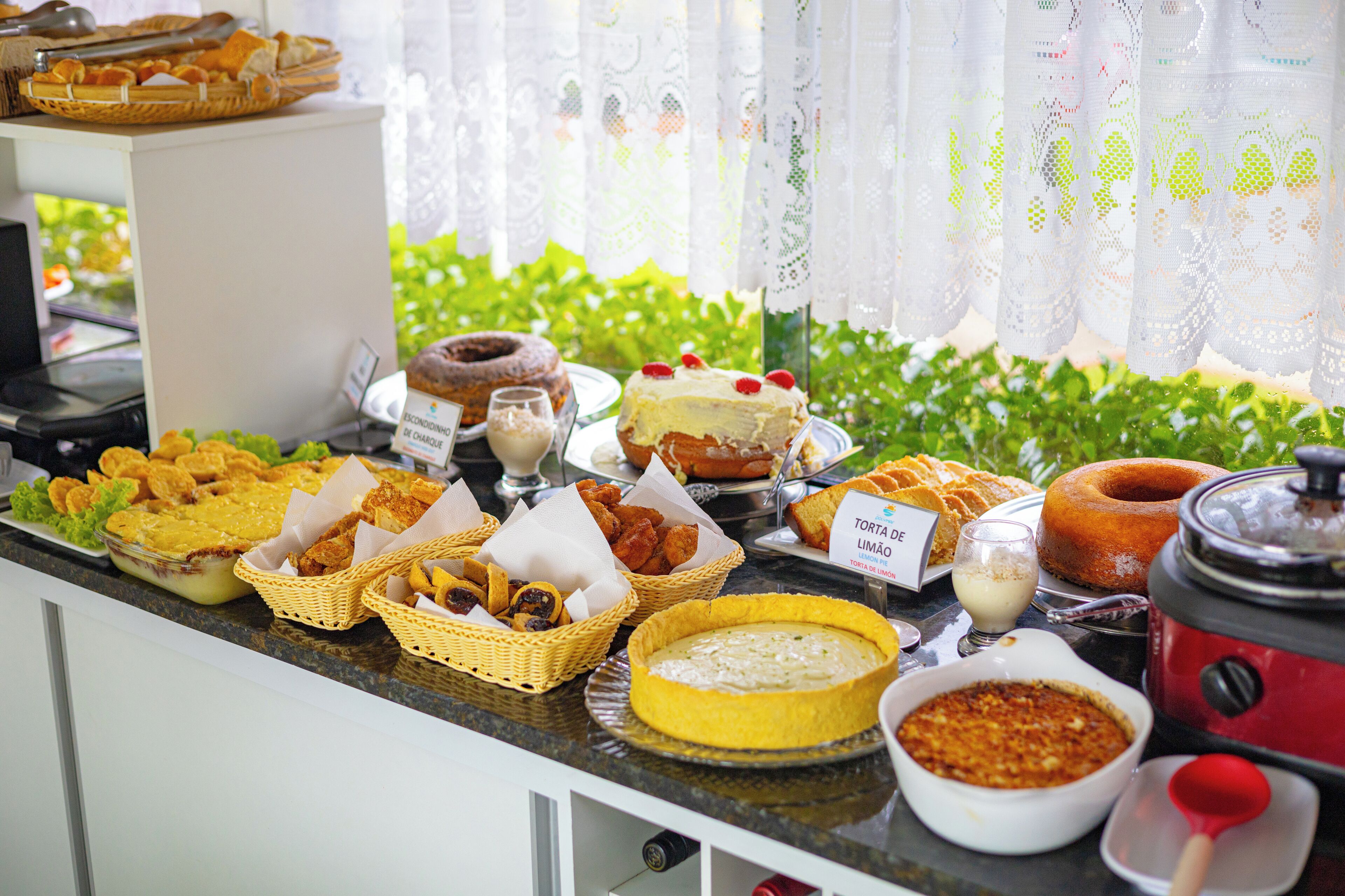 A buffet with various dishes including a cake, bread, and a variety of side dishes.