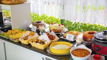 A buffet with various dishes including a cake, bread, and a variety of side dishes.