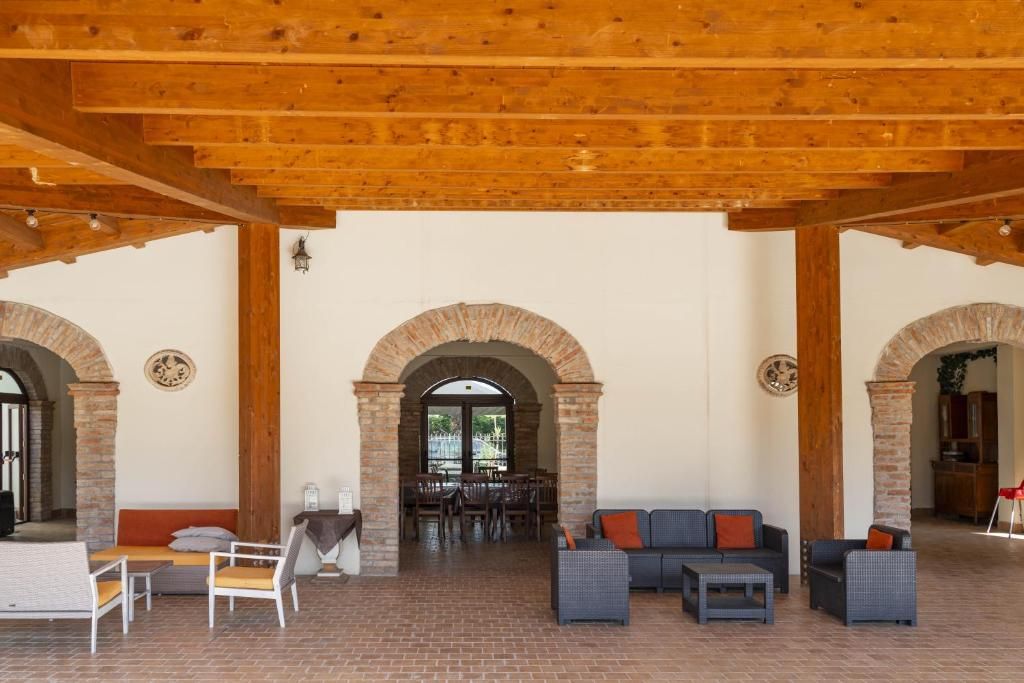 Un espacio habitable de concepto abierto con suelo de ladrillo, vigas de madera y una zona de comedor con mesas y sillas.