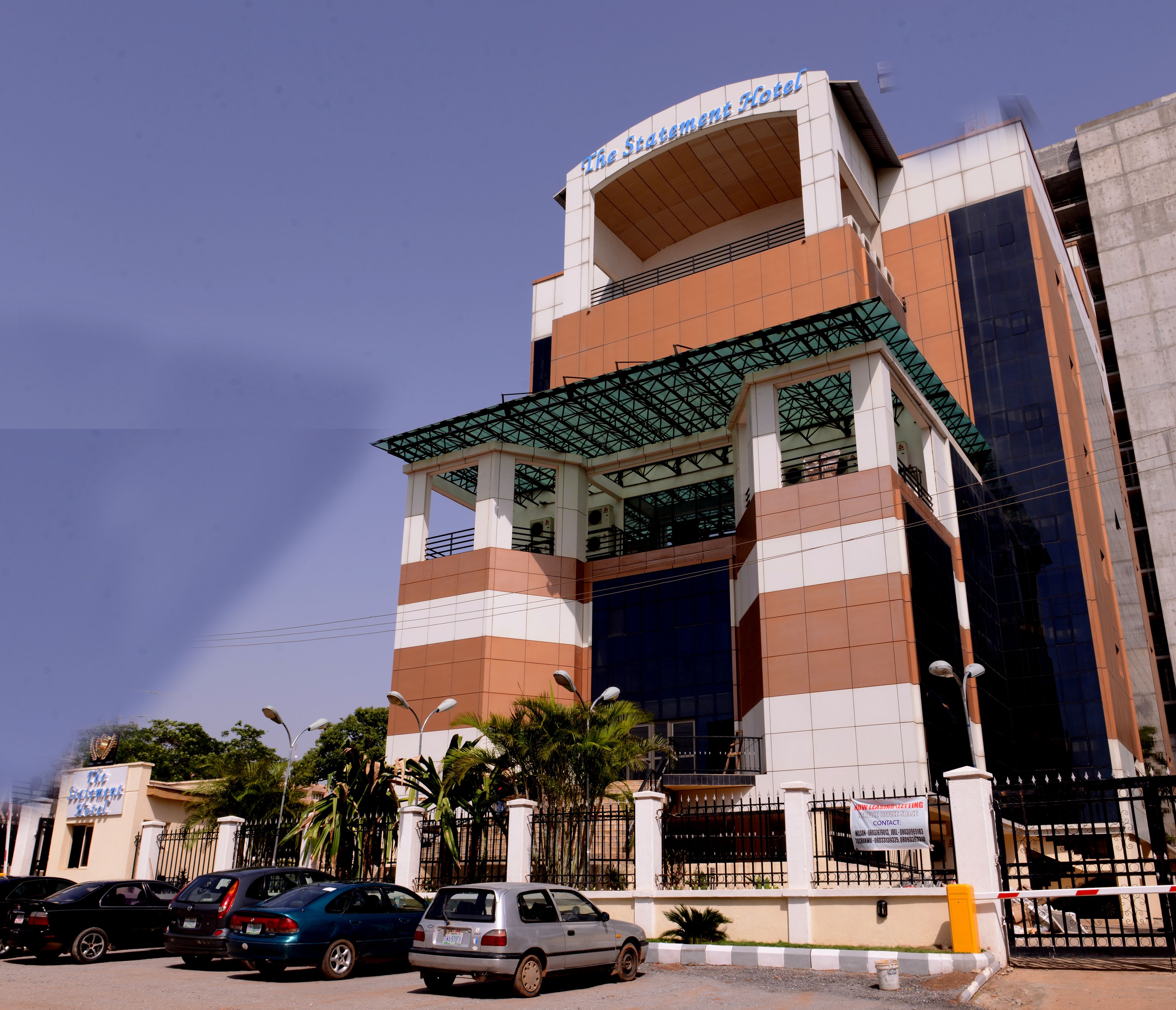 A hotel with a modern architectural design, featuring a prominent entrance with a glass canopy and a sign above the entrance.