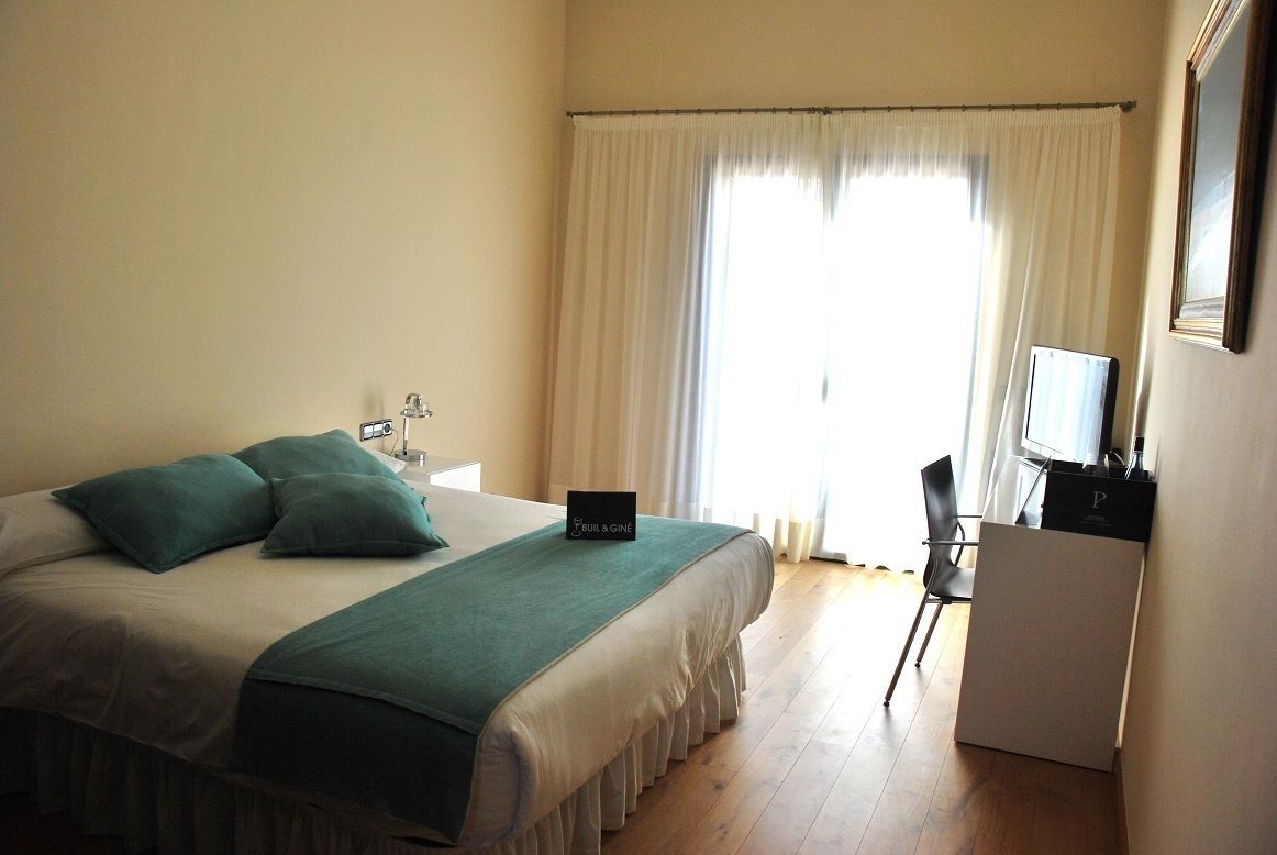 A hotel room with a bed, a desk, and a chair.