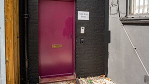 A red door with a sign indicating 'Mile End Beds'. - Mile End Beds - Hostel (London)