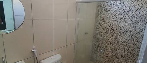 A bathroom with a toilet, sink, and shower.