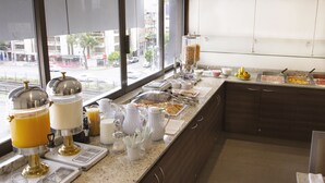 Un bufé de desayuno con diversas opciones de comida y bebidas.