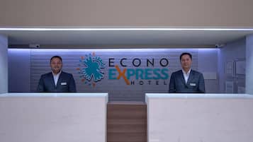 A reception desk at the Econo Express Hotel with a modern design and a logo on the wall.