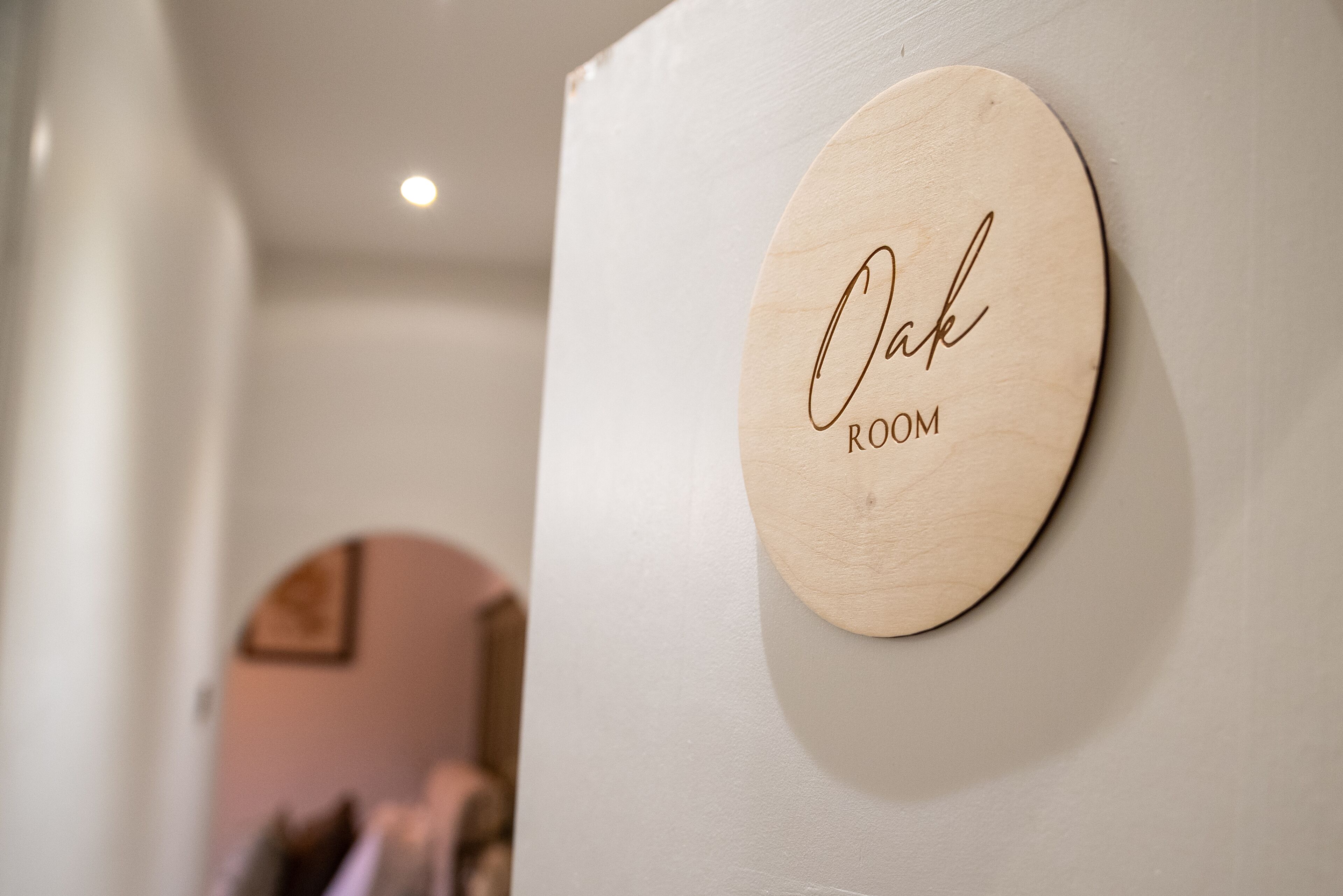A wooden sign with the text "Oak Room" mounted on a wall.