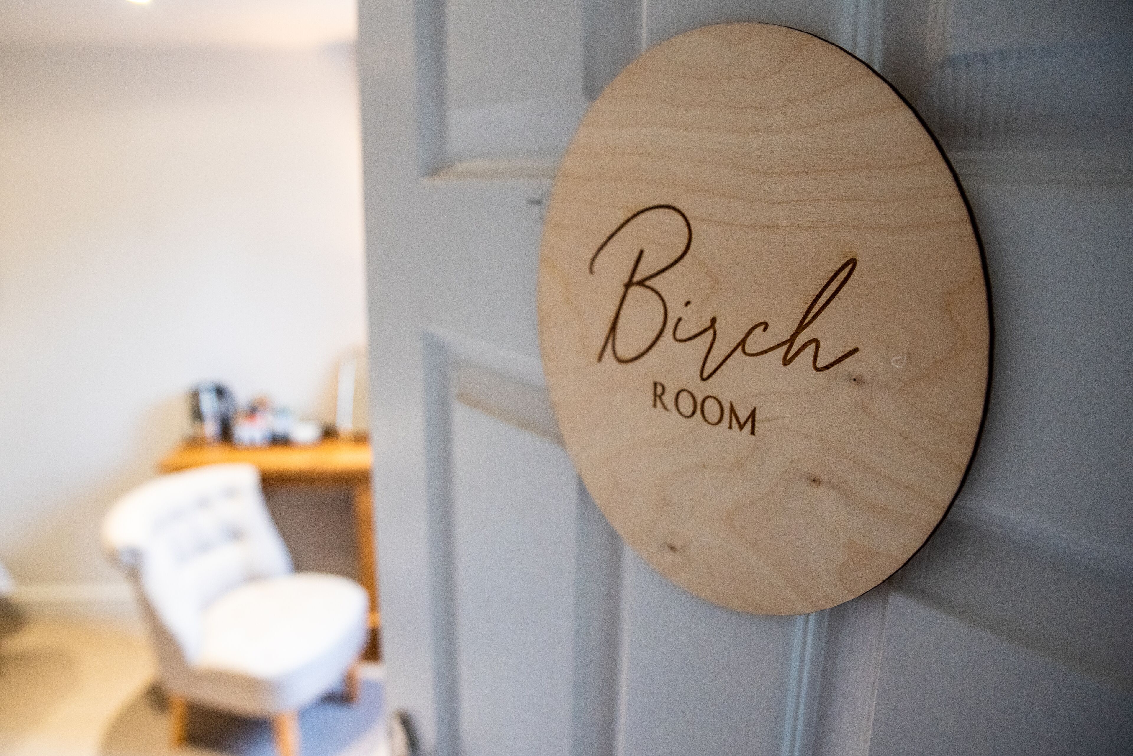 A wooden sign with the text "Birch Room" on a door.