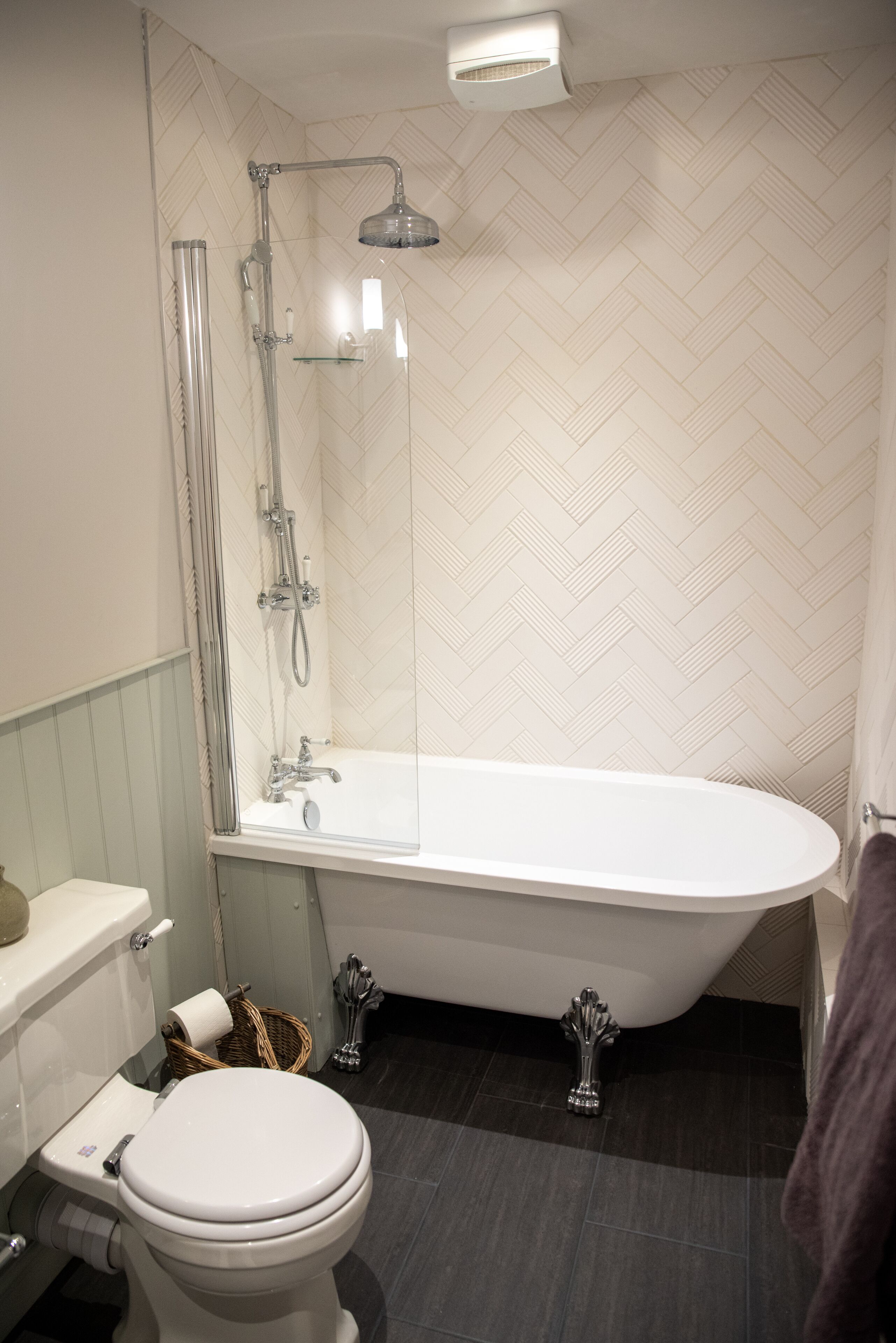 A bathroom with a freestanding bathtub, a toilet, and a shower area.