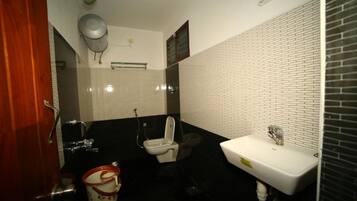A bathroom with a toilet, sink, and shower.