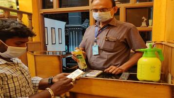 A man at a counter with a spray bottle and a mobile phone.