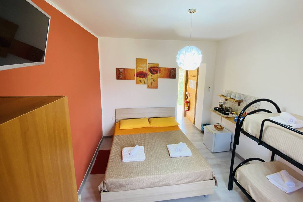 A hotel room with a bed, a desk, a chair, and a TV.