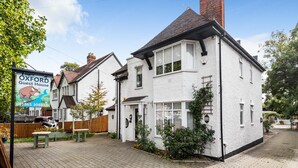 A two-story white house with a signboard advertising a guest house. - Oxford Guest House (Oxford)