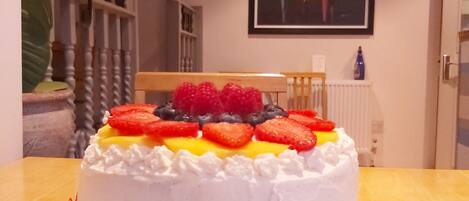 Un pastel con fruta sobre una mesa en una habitación, con un piano al fondo.
