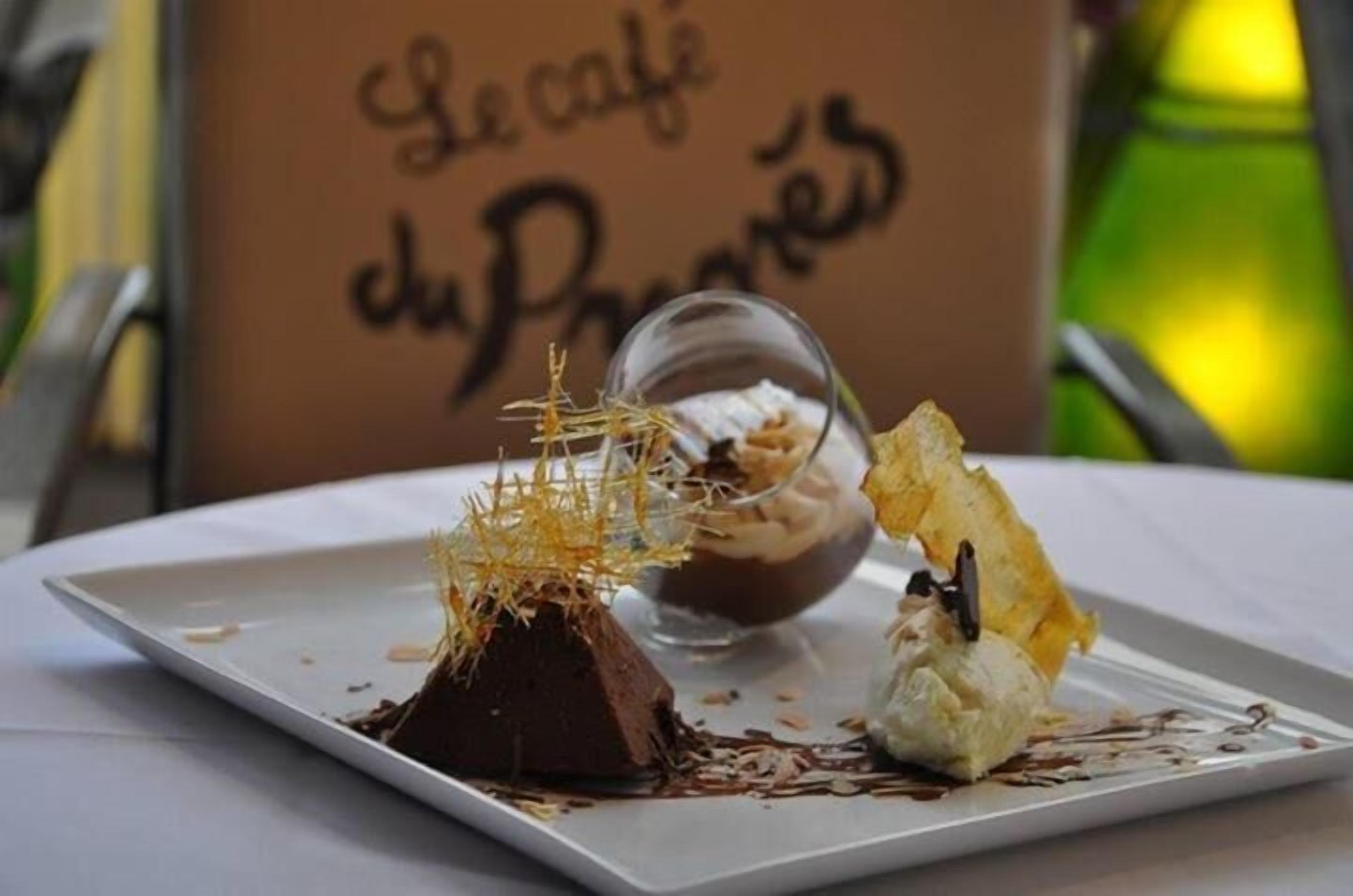 A dessert plate with chocolate and ice cream, garnished with chocolate shavings and a decorative element.