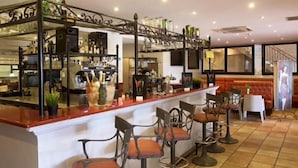 A bar area with a counter, stools, and a decorative metal railing. - Hostellerie du Cigalou (Bormes-Les-Mimosas)