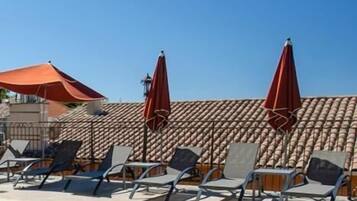 Piscine extérieure, parasols de plage, chaises longues