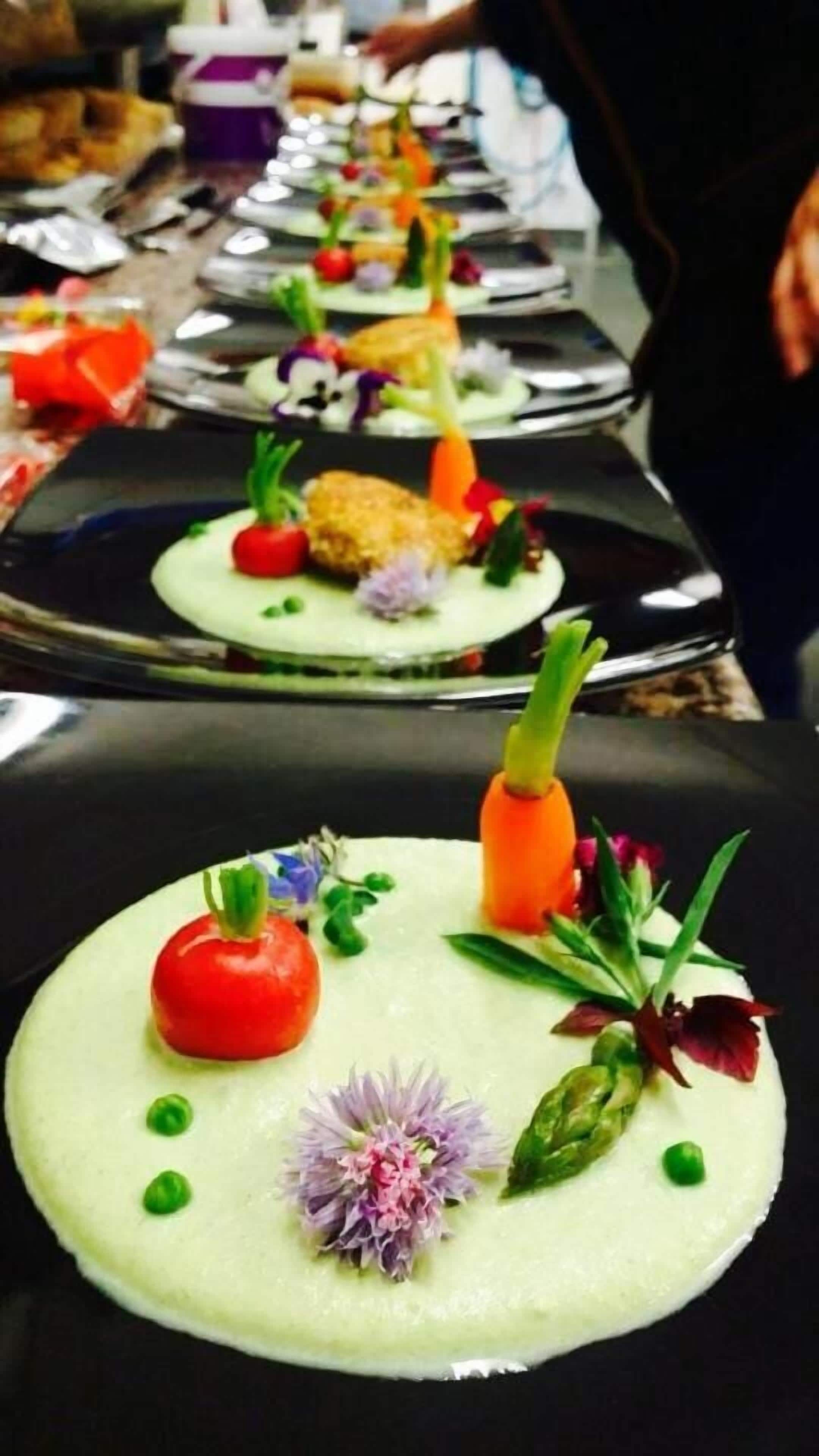 Una fila de platos elegantemente emplatados con diversas guarniciones.